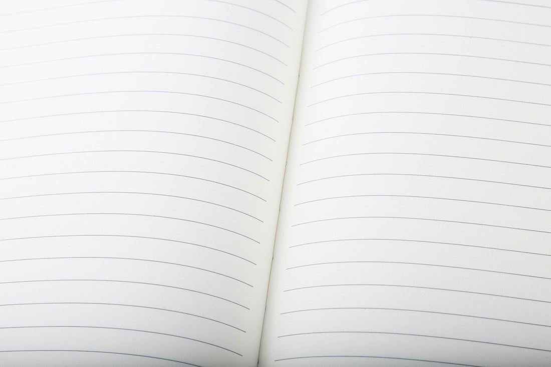 Open notebook showing lined paper with centre fold, ready for handwritten notes or planning.