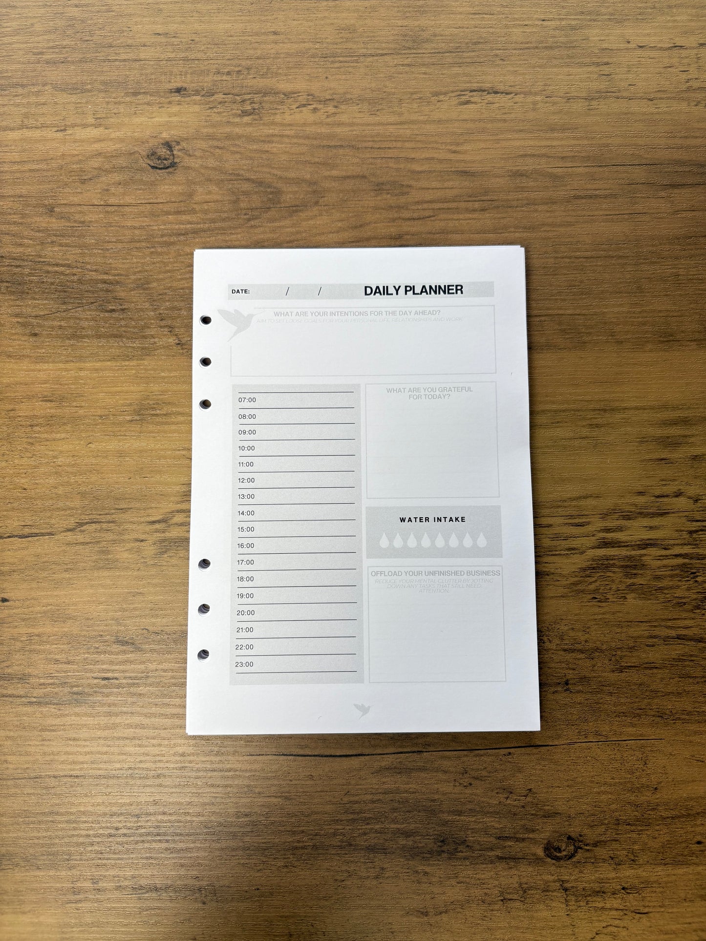 Hummingbird Paper Co Daily planner sheet on a wooden surface