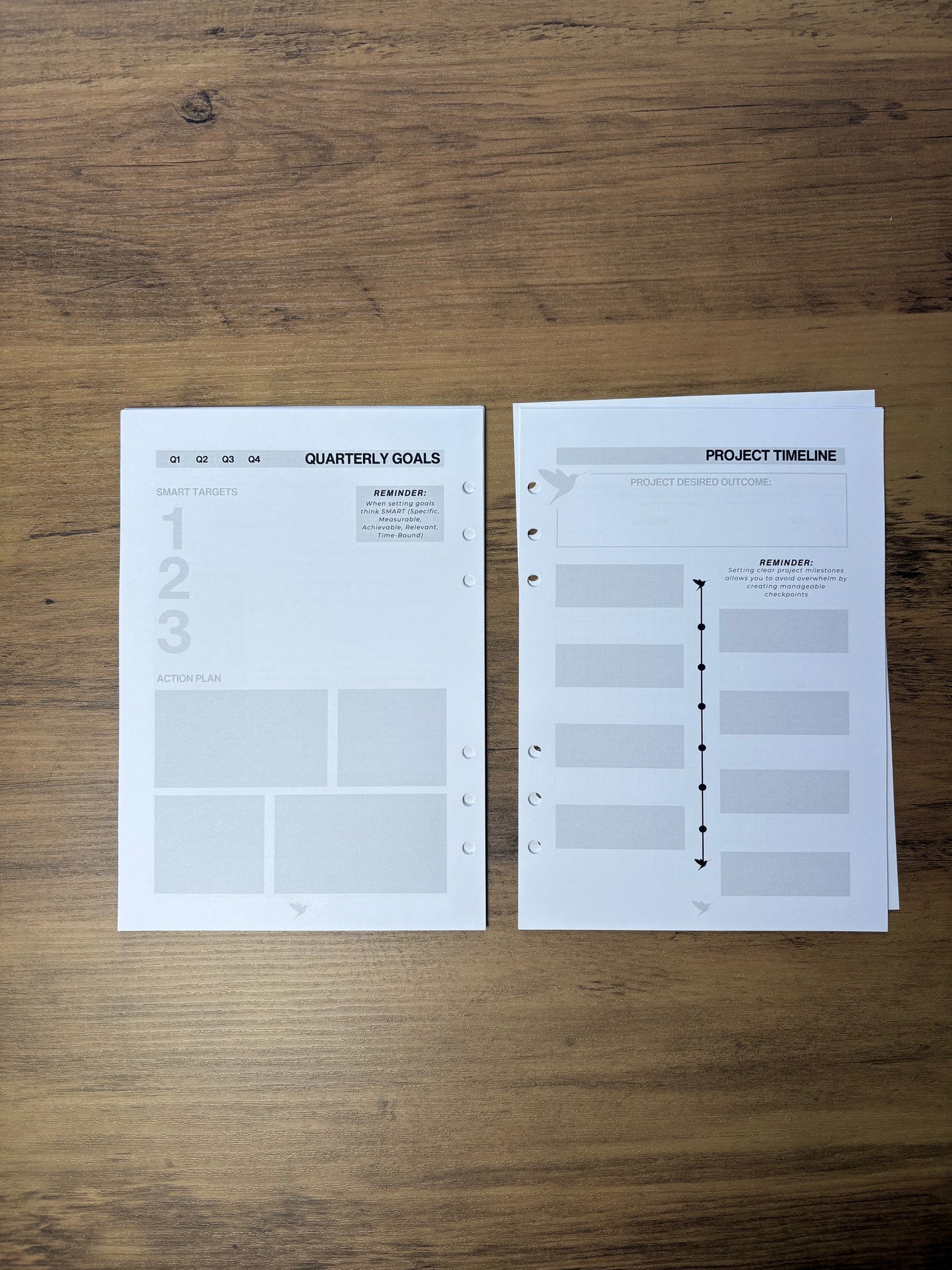 Two sheets of paper with planning or organizational templates on a wooden surface
