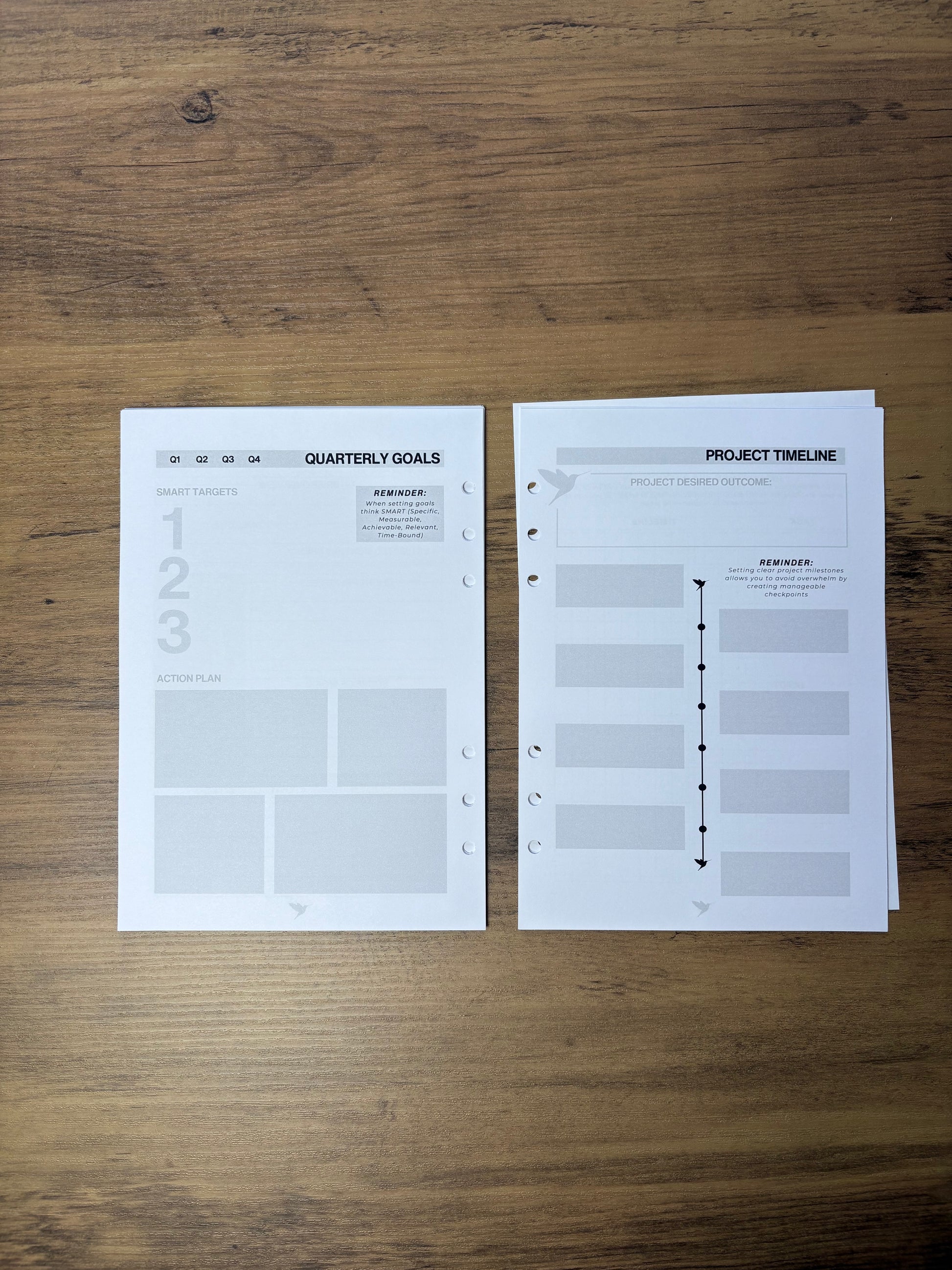 Two sheets of paper with planning or organizational templates on a wooden surface