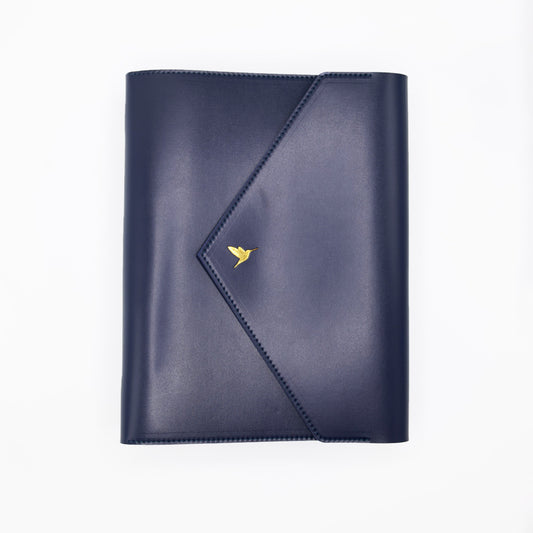 The Hummingbird Planner in navy vegan leather, featuring a gold foil hummingbird stamp. This customisable A5 planner is shown closed from the front, highlighting the premium personalised planner cover and elegant gold hardware.