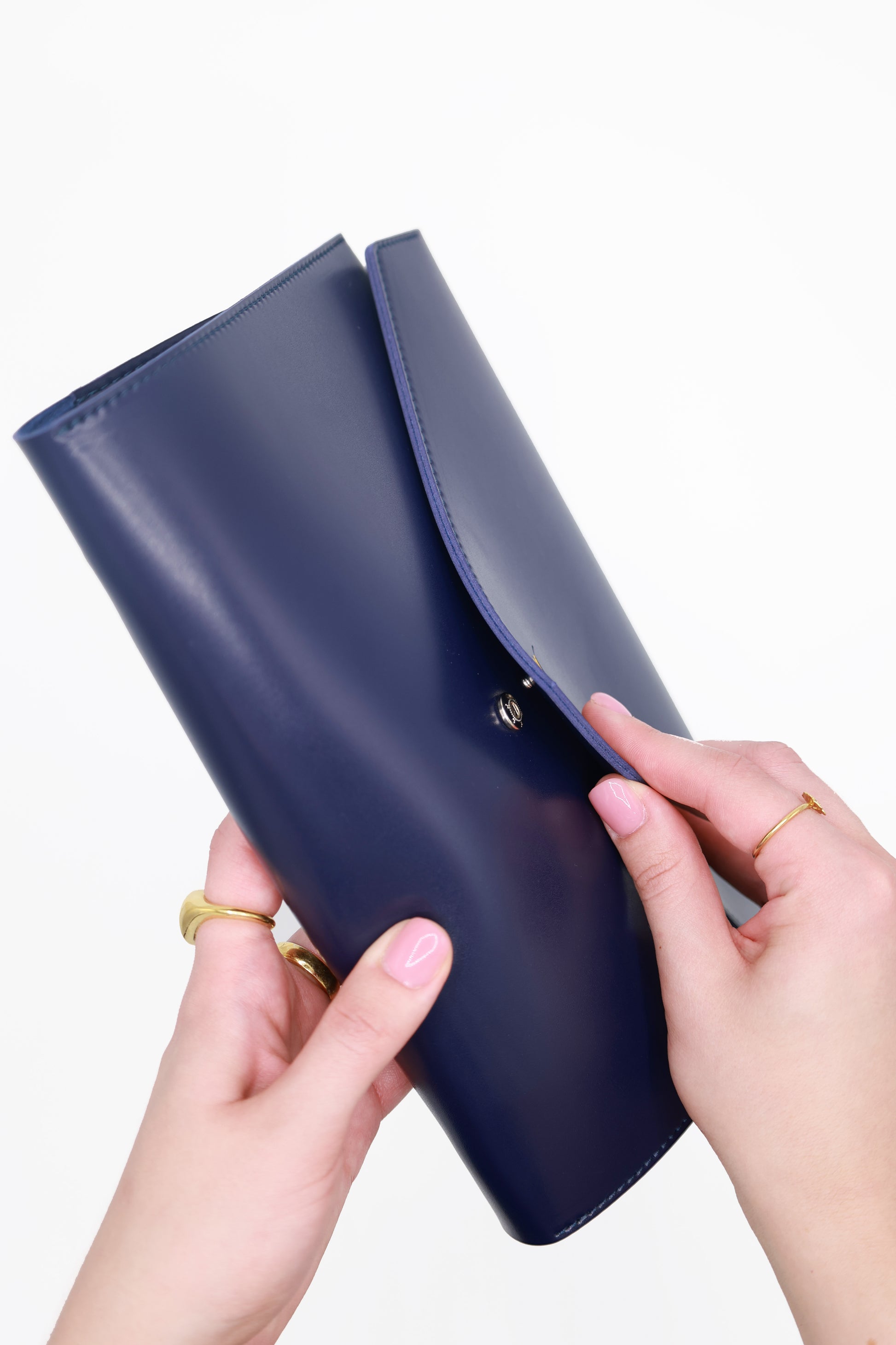 Hands opening The Hummingbird Planner in navy vegan leather, shown from the side. The custom A5 planner reveals its refillable ring binding system, highlighting the personalised planner in use as part of a flexible, customisable planning setup.